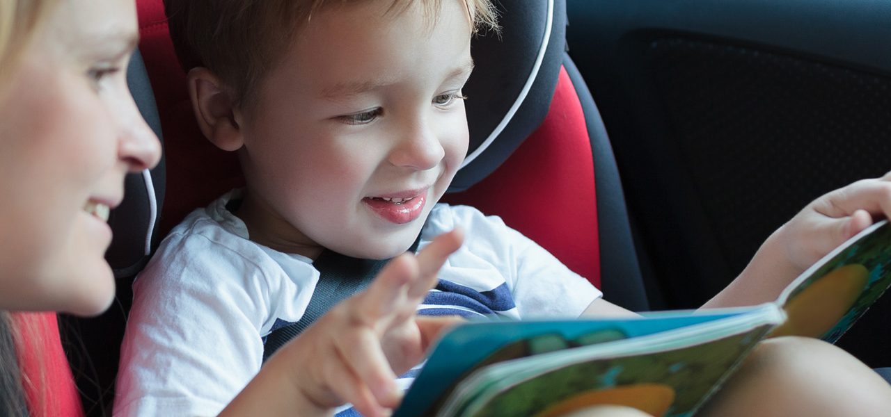 Poika lukee äidin kanssa kirjaa autossa